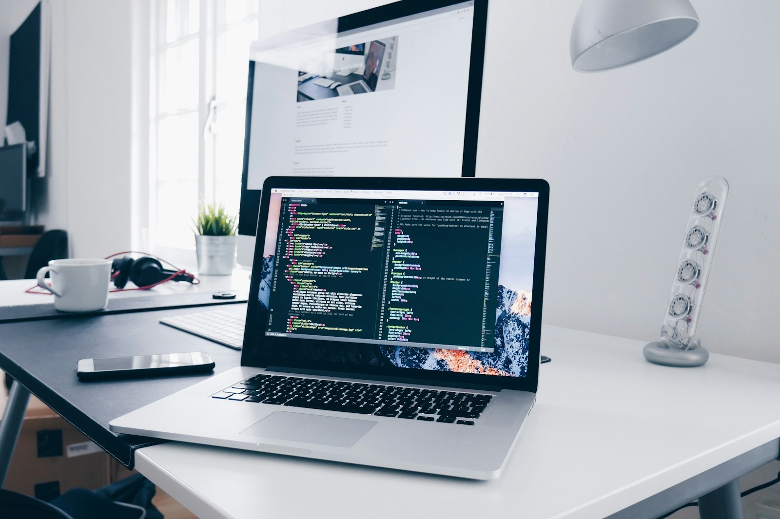 A working desk with a laptop and notes, representing application design and implementation
